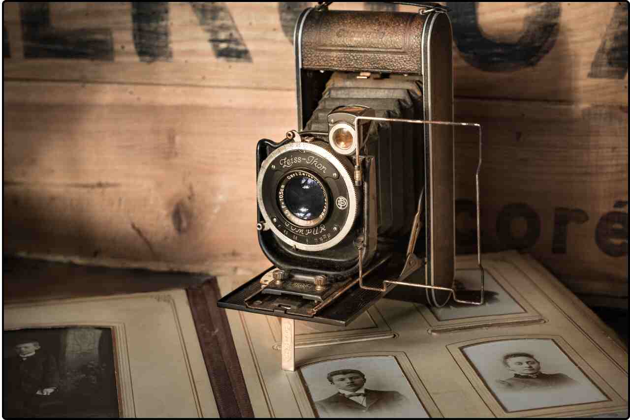 Vintage black camera with leather accents on a textured brown surface.